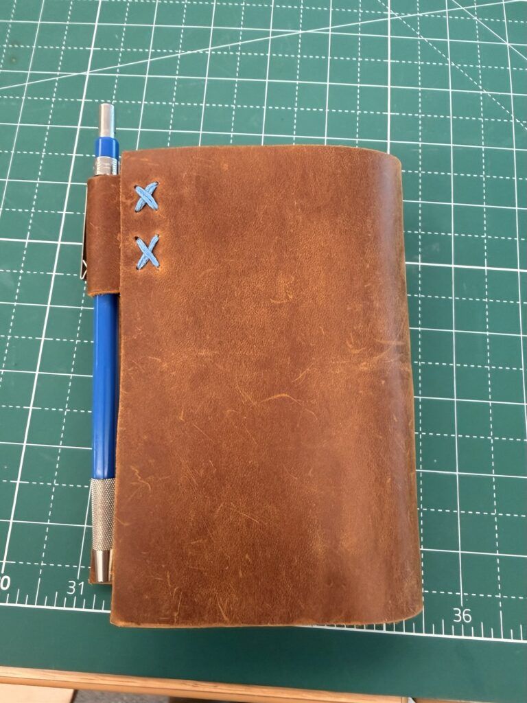 I had a little bit of leather left and stitched a pencil loop to the back cover.